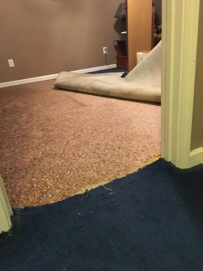 Carpet pad removal revealing water damage during Water Mitigation Services in Oklahoma City